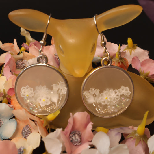 Elegant floral resin earrings with white flowers and beads in a silver frame