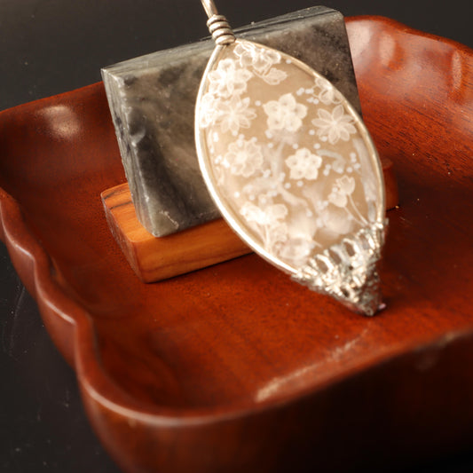 Floral Elegance Stainless Steel and Resin Pendant with intricate white floral patterns