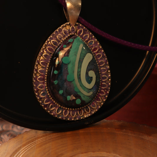 Teardrop Swirl Polymer Clay Pendant with intricate silver frame and purple cord