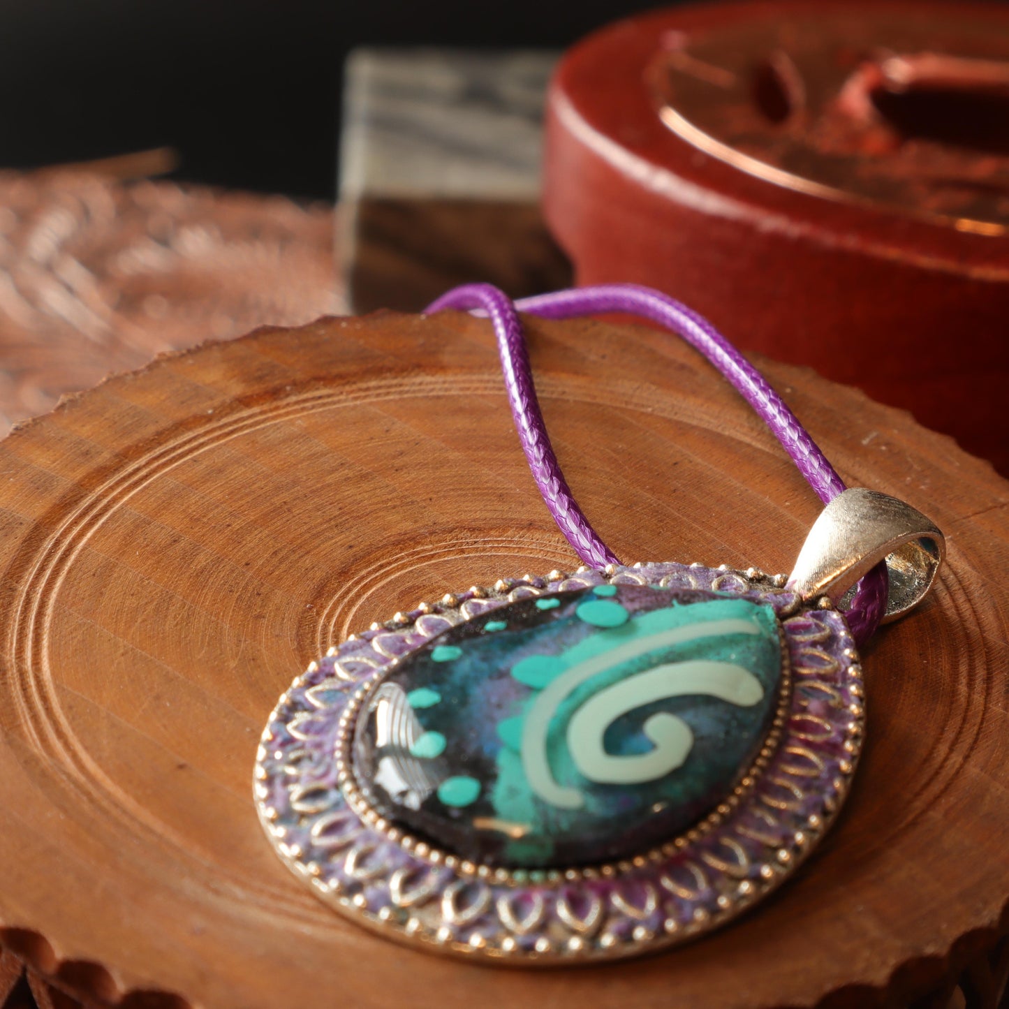 Teardrop Swirl Polymer Clay Pendant with intricate silver frame and purple cord