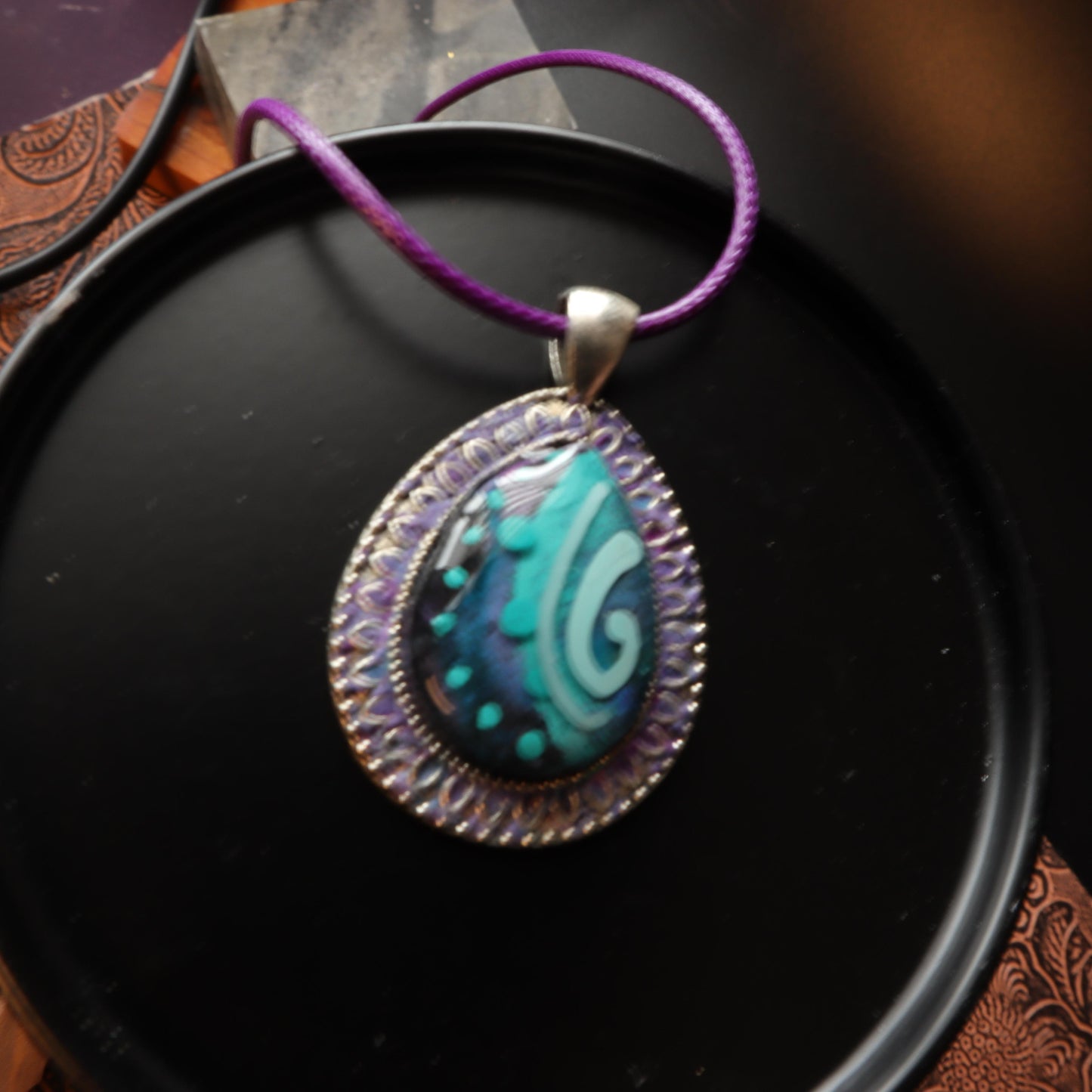 Teardrop Swirl Polymer Clay Pendant with intricate silver frame and purple cord