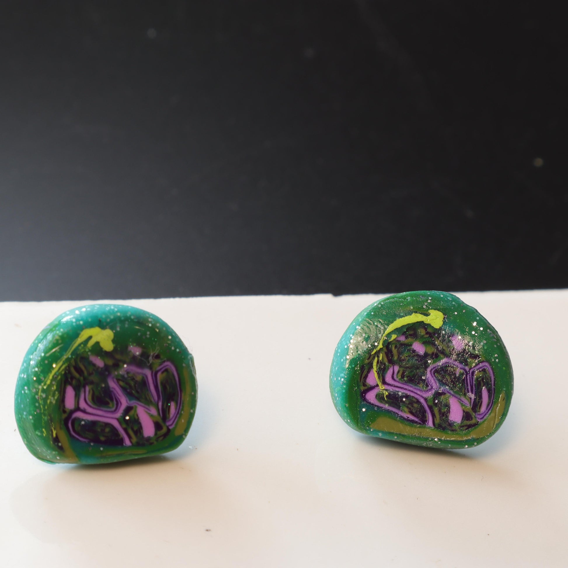 Handmade polymer clay earrings in vibrant blue and green shades, with sparkling embellishments