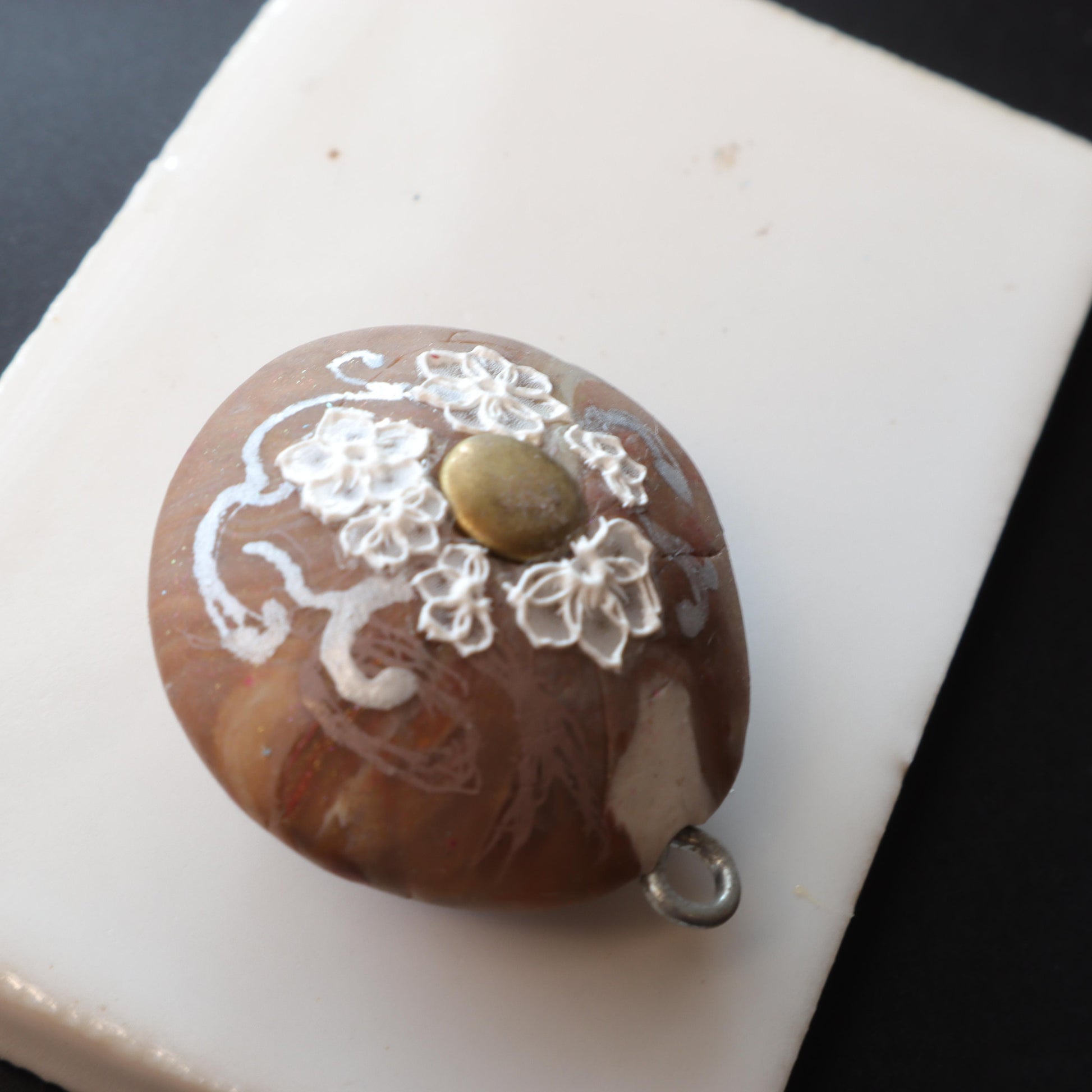 Elegant polymer clay pendant with floral detailing and metallic accents