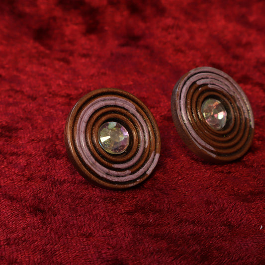 Upcycled button earrings with a concentric spiral design and rhinestone center